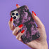 Gothic phone case featuring Victorian toile pattern in dusty rose pink on charcoal background, with skeleton unicorns, peacocks, roses, and botanical elements.